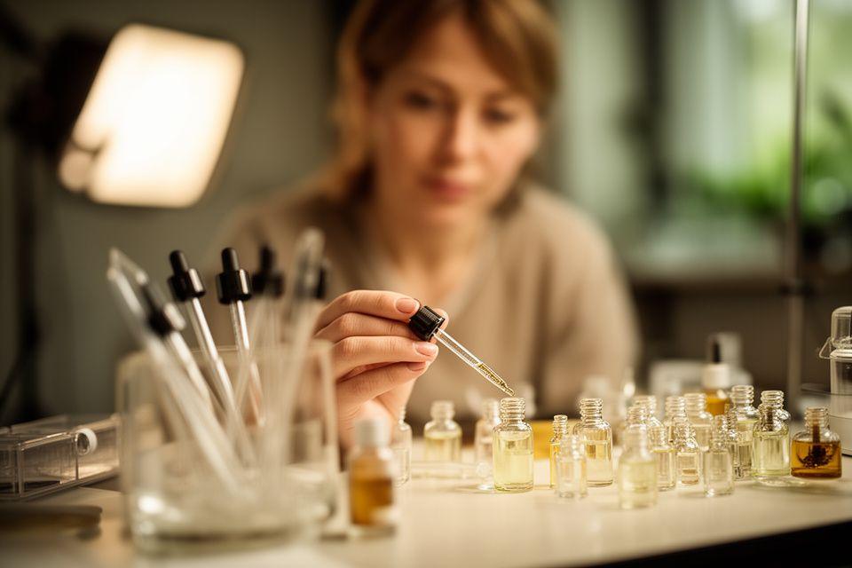 Parfümeur am Arbeitstisch mit Pipetten und Probenfläschchen im Zürcher Atelier